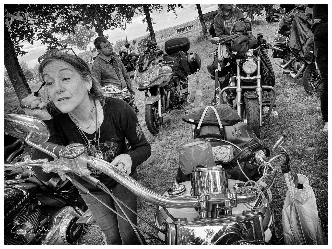 Une bikeuse sourit, penchée sur sa moto